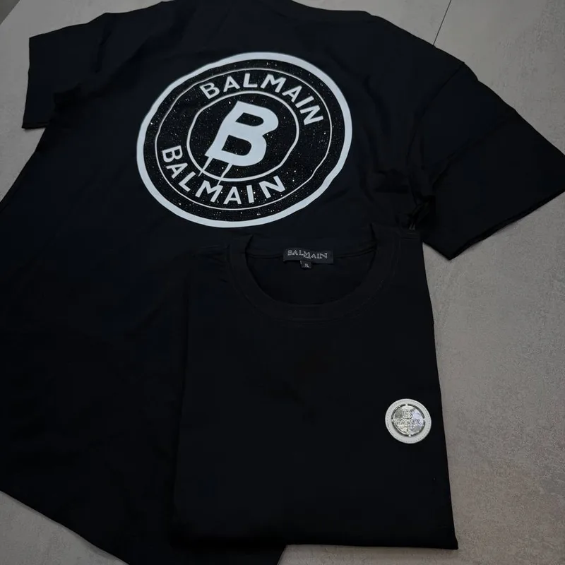 Camiseta Balmain preta patch frontal e estampa circular branca costas