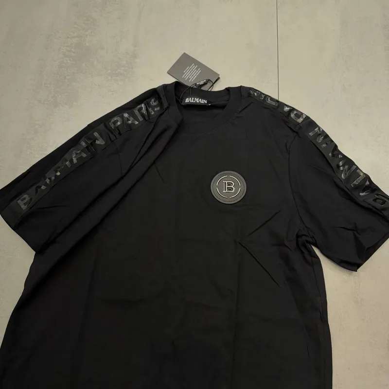 Camiseta Balmain preta patch B frontal e escrita nas mangas