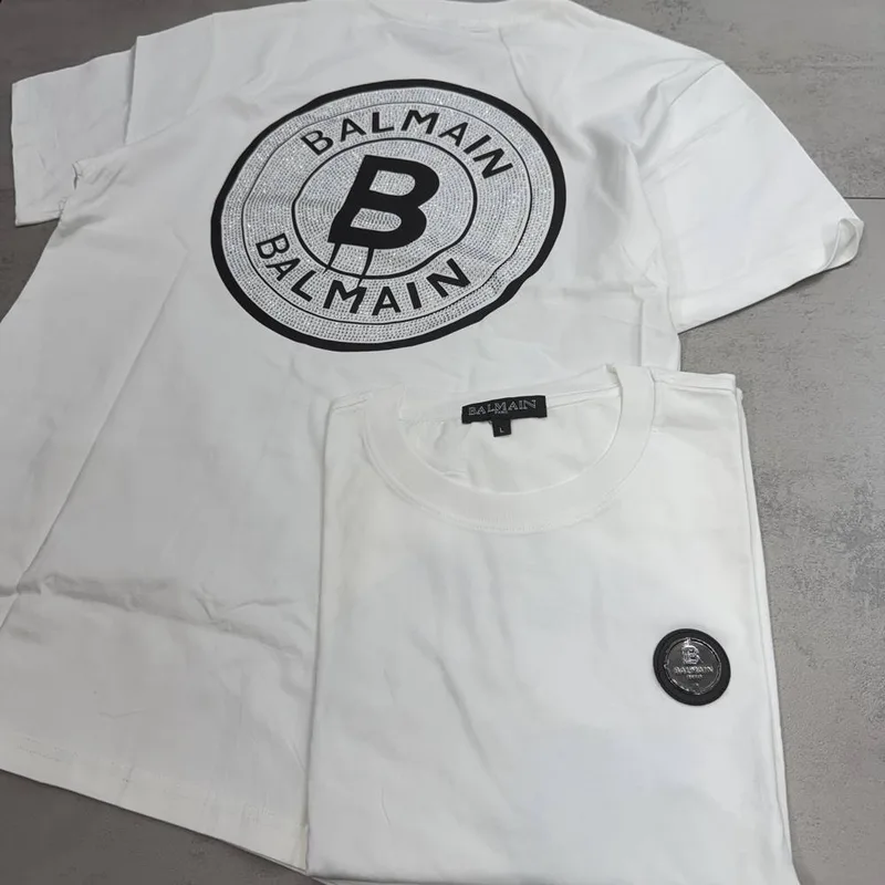 Camiseta Balmain branca patch frontal e estampa circular prata costas